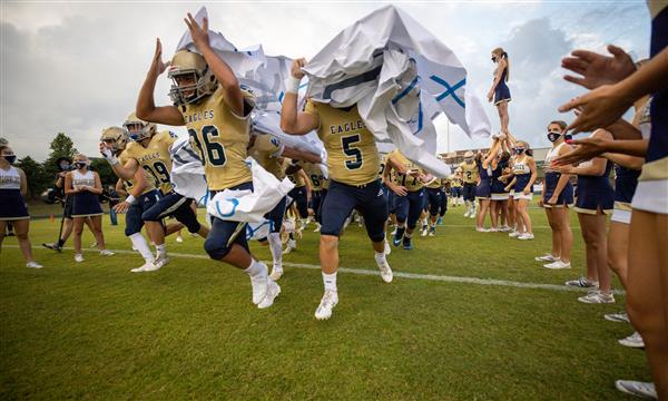 Independence High football team runs through banner